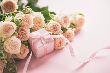 Pembe gül çiçek ve Hediyelik veya mevcut kutusu pembe arka plan. Anneler günü, Doğum günü, Sevgililer günü, Bayan gün, kutlama kavramı. Metin için yer.