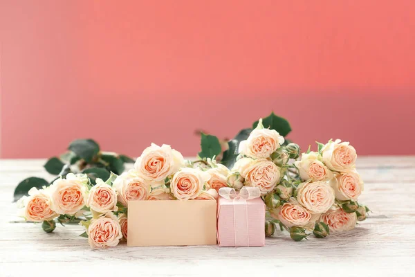 Pink roses flowers and gift or present box pink background. Mothers Day, Birthday, Valentines Day, Womens Day, celebration concept. Space for text.