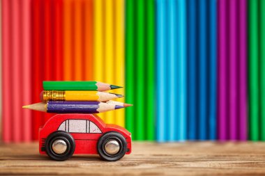 Renkli kalemler hamuru çok renkli duvar üzerinde taşıyan minyatür araba kırmızı. Geri okul kavramı