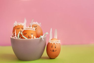 Komik Paskalya tavşanları yumurtalar pembe kağıt arka plan kopya alanı ile ıslak zeminde. Mutlu Paskalya kavramı.