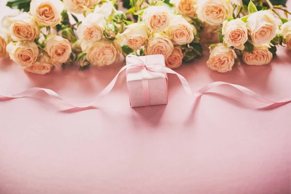 Pink roses flowers and gift or present box pink background. Mothers Day, Birthday, Valentines Day, Womens Day, celebration concept. Space for text.