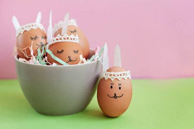 Komik uyku Paskalya tavşanları yumurtalar pembe kağıt arka plan kopya alanı ile ıslak zeminde. Mutlu Paskalya kavramı.