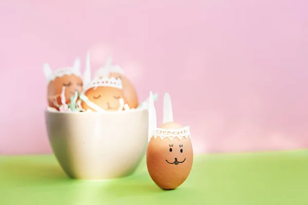 Забавные пасхальные яйца пасхальные кролики в миске на розовом бумажном фоне с копировальным местом. Happy Easter . — стоковое фото