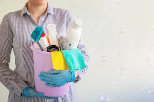 Limpiador hembra sosteniendo un cubo con suministros de limpieza . — Foto de Stock