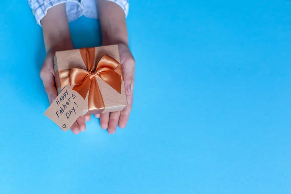Happy Fathers Day concept. Kinderen handen Holding present Box voorvader op blauwe achtergrond. — Stockfoto