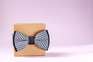 Bir hediye kutusu Craft kağıt sarılmış ve pembe arka planda yay ile bağlı.