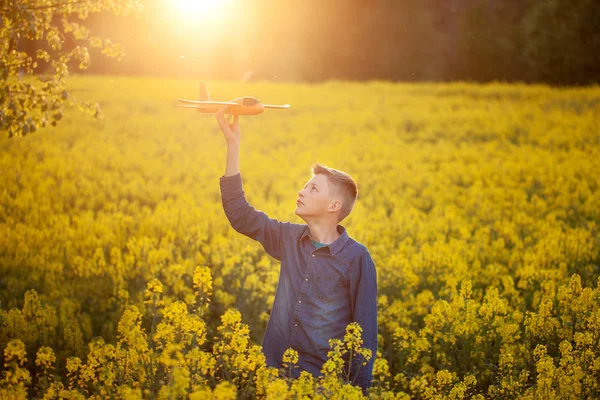 孩子在日落时与玩具飞机玩耍，在夏日梦想旅行. — 图库照片