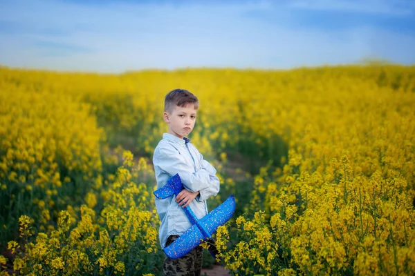 Boy plays with a toy airplane in summer day. — Stock Photo, Image