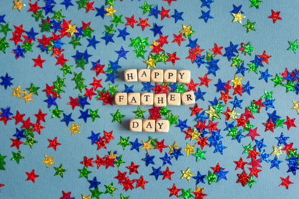 Happy Father day greeting car with colorful confetti on blue-gray background.