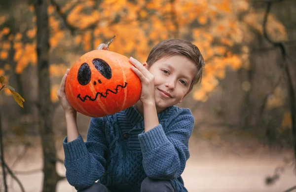 Egy tököt szorongató fiú. Az ünnepek fogalma. Felkészülés Halloweenre. — Stock Fotó