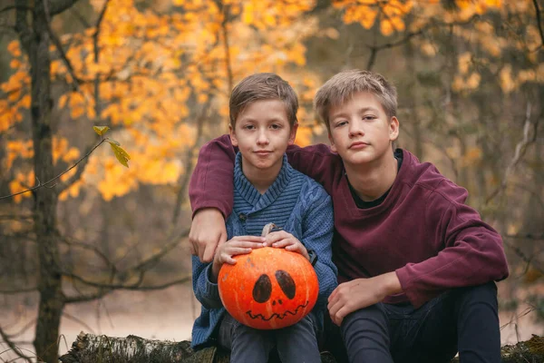 Két fiú egy tökkel a kezében. Az ünnepek fogalma. Felkészülök Halloweenre. Szüret. — Stock Fotó