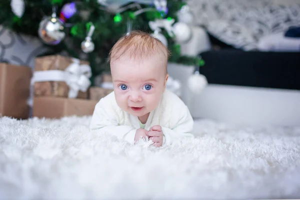 Ritratto di neonato sorridente sdraiato vicino all'albero di Natale . — Foto Stock