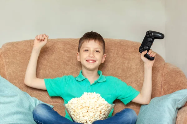 Niño Jugando Videojuegos Línea Comiendo Palomitas Maíz Sentado Sofá Sala — Foto de Stock