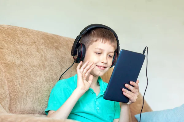 Chłopiec Korzystający Tabletu Cyfrowego Słuchawek Wideokonferencji Kanapie Salonie — Zdjęcie stockowe