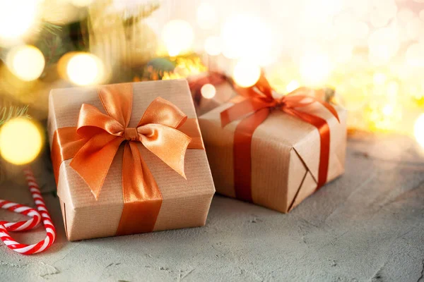 Rustikální retro dárky, prezentovat krabice na pozadí bokeh. Vánoce. Ručně vyrobený papírový obal. — Stock fotografie