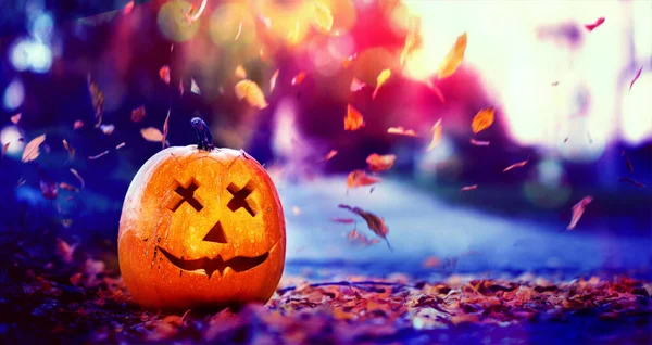 Halloween faragott tök fej jack lámpa ősszel levelek természet háttér. — Stock Fotó