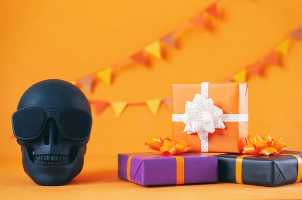 할로윈 화려 한 선물 상자에 주황색 배경에 해골이 있어. 생일, 생일, 할로윈 파티 컨셉트. — 스톡 사진