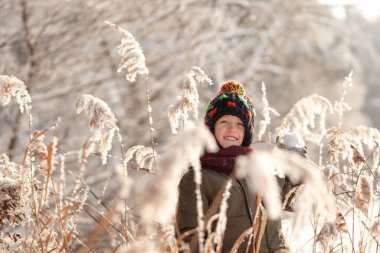 Kış zamanı. Tatlı çocuk kış ormanında taze karla oynarken eğleniyor. Karlı kış gününde çocuklar için açık hava eğlencesi