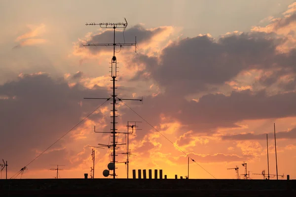 Television antennas on the roof pictured at sunset in Prague, Czech Republic.