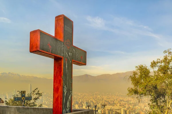 Big red cross at boundaries of railing and aerial cityscape of santiago de chile at background in san cristobal hill viewpoint