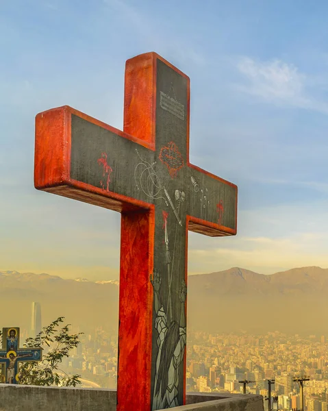 Big red cross at boundaries of railing and aerial cityscape of santiago de chile at background in san cristobal hill viewpoint