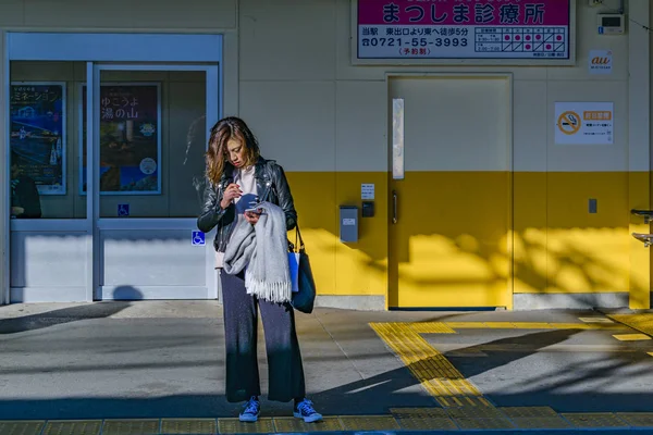 Mujer mirando su celular en la calle, Osaka - Japón — Foto de Stock