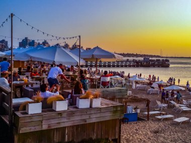PUNTA DEL ESTE, URUGUAY, FEBRUARY - 2020 - Summer scene waterfront bar at crowded mansa beach in punta del este city, Uruguay clipart