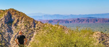 Kurak kayalık arazi dağlarının kenarında duran adam San Juan, Arjantin 'de sahne aldı.