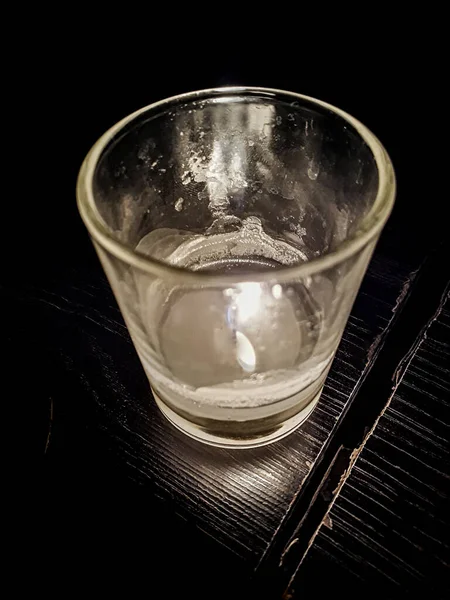 Dark high contrast photo Hhgh angle candle on glass over table