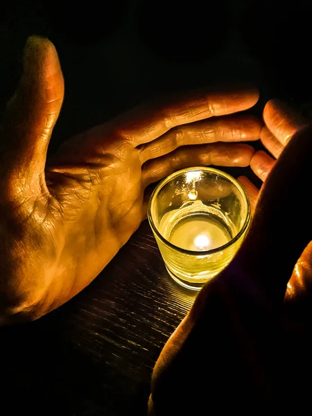 Homme Mains Couvrant Bougie Sur Verre Sur Table — Photo