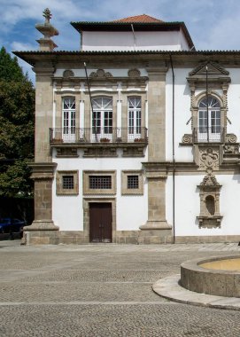 Portekiz 'in Guimaraes Meydanı' nda süslü pencereli ve taş çeşmeli tarihi sarayın ön cephesi.. 