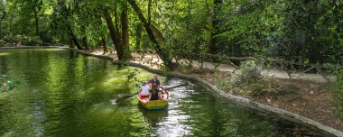 Braga, Portekiz: 14 Ağustos 2023: Yüksek açı manzaralı yaz manzarası aile kürek çekerken Bom Jesus Park Gölü, Braga Şehri, Portekiz