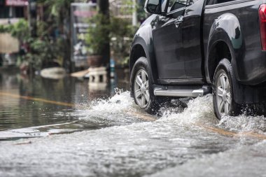 Kamyonet, su dolu bir cadde üzerinde.