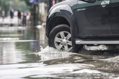 Kamyonet, su dolu bir cadde üzerinde.
