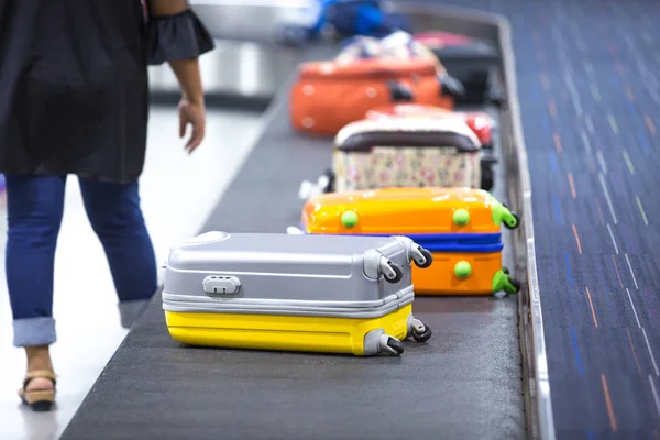 Wheeled suitcase on a luggage belt at the airport terminal.