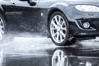 Spor araba yağmurlu yollarda tahrik yakın çekim üstünde a tekerlek ile motion blur efekti