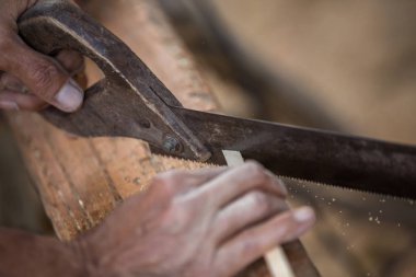 Erkek marangoz atölyesinde ahşap tahta üzerinde elektrikli araçlarla çalışma.