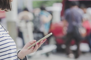 Kadın taksi taksi veya diğer taşıma modları sipariş bir akıllı telefon ile.