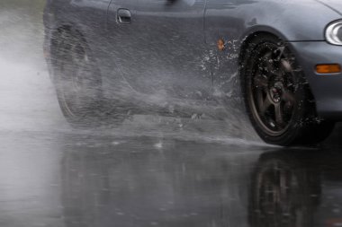 Spor araba yağmurlu yollarda tahrik yakın çekim üstünde a tekerlek ile motion blur efekti