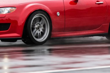 Spor araba yağmurlu yollarda tahrik yakın çekim üstünde a tekerlek ile motion blur efekti