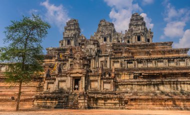 Angkor tapınakları, Siem Riep, Kamboçya - 12 Şubat 2018: Üç piramit şeklindeki bir tapınak bir ağaç önde ve mavi gökyüzü altında kuleleri