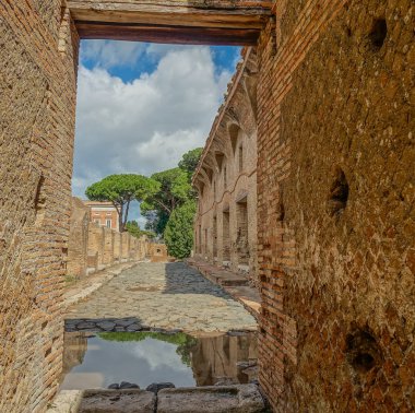 Ostia Antica, Rome, İtalya: 3 Eylül 2017: Roma kalıntıları küçük bir kemer ve Ostia Antica, Rome ağaçlarının görünümü