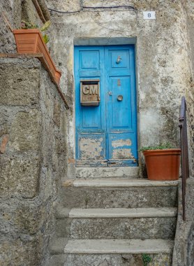 Calcata, Lazio, İtalya - 9 Eylül 2017: Eski bir merdiven Calcata, İtalya üzerinden erişimi olan renkli kapı mavi