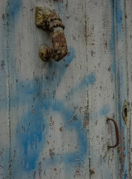 Villefranche de Rouergue, Midi Pyrenees, France - September 16, 2017: Old rusty knob on a wooden door in blue tones