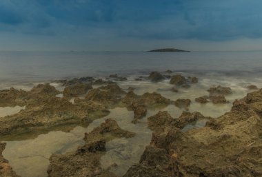 Mallorca, Balear Adaları, İspanya - 27 Ekim 2018: Planda küçük bir ada ile düşük tide, kayalık bir plajda uzun pozlama