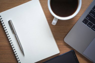 Ofis masaları ile akıllı telefon ve dijital tablet ve grafik mali iş belgeleri ile sosyal ağ diyagramı ve bilgisayar laptop ahşap masa