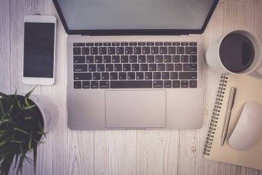 Üstten görünüm laptop ve smartphone ahşap Resepsiyon iş kahve, küçük bir ağaç ve online alışveriş ile çalışma.