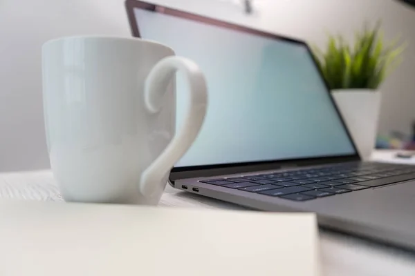 Yan görünümü laptop ve smartphone üzerinde alışveriş online ve ahşap Resepsiyon iş kahve, küçük bir ağaç ile çalışma.