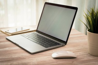 Yan görünümü laptop ve smartphone üzerinde alışveriş online ve ahşap Resepsiyon iş kahve, küçük bir ağaç ile çalışma.