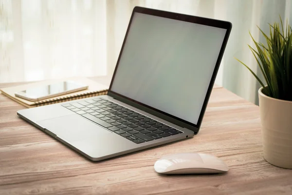 Yan görünümü laptop ve smartphone üzerinde alışveriş online ve ahşap Resepsiyon iş kahve, küçük bir ağaç ile çalışma.